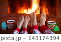 The family is sitting in front of the fireplace. Mother and child in clothes with Christmas ornaments are having fun at home. Slow motion 143174394