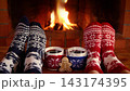 The couple is sitting in front of the fireplace. People in clothes with Christmas ornaments are having fun at home. Slow motion 143174395