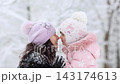 Mother and child are having fun outdoors in winter forest. A family plays in a nature park against a snow covered trees background. Healthy lifestyle and winter holidays concept. 143174613