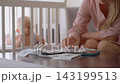 Close-up of mother calculating household expenses on phone. Financial stress of motherhood. 143199513