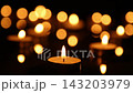 Two Lit Candles Burning Below Rows of Golden Bokeh Lights 143203979
