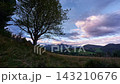 Time Lapse Of Clouds Over Mountain Range Framed By Lone Tree Silhouette 143210676