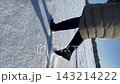 Walking on fresh snow in a winter landscape with sunny skies and trees 143214222