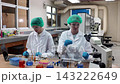 Laboratory room. Female scientists conducting laboratory research with colorful chemical samples. Using test tubes flasks and microscopes for scientific analysis and experimentation. Bio or chemical. 143222649