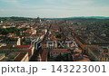 Elevated drone perspective reveals the Duomo above dense Renaissance-era streets, warm roof tiles and the distant Tuscan landscape. 143223001