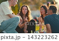 Friends gather at a park to enjoy a meal and share conversations during a sunny day 143223262