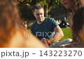 Mature man adjusting his smartwatch at park picnic 143223270