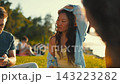 People relax on a sunny day by the water while enjoying time outdoors 143223282