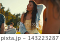 Group of friends enjoying a sunny day outdoors in the park while sharing stories and laughter 143223287