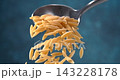 Orzo pasta falling from a spoon in super slow motion on blue background close up 143228178