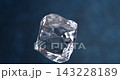 Clear ice cube falling in slow motion macro close-up against a blue background 143228189