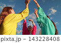 Dancing party, group happy girls raising arms to sky on beach. People are having fun outdoors, dancing on ocean beach, relaxing on island. People dance at music concert, raising their hands in air 143228408