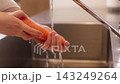 一位家庭主婦在廚房裡洗胡蘿蔔的手。 143249264