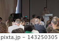 Conference audience with people moving near the lectern 143250305