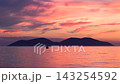 Stunning sunset over calm sea with distant islands silhouette and small boat floating on peaceful water surface during dusk. Adriatic sea near the city of Vlore in Albania, Europe. 143254592
