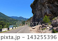 Cliffside highway provides access, wide view beside Jvari Reservoir with exposed rock walls and roadside debris in Georgia, documenting geotechnical risk, route maintenance and transport safety 143255396