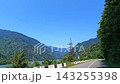 Svaneti road follows reservoir, wide view of Jvari's turquoise water and forested Caucasus slopes in Georgia, documenting regional travel access, mountain transport and destination tourism 143255398