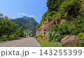 Vehicle travels mountain road, forward view through a forested Georgian valley with rock cliffs and guardrail, supporting road trip tourism, regional transport and destination travel marketing 143255399