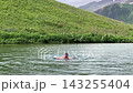 Male swimmer swimming wide view in Namkuami Lake in Svaneti, Georgia, showing cold-water recreation, mountain wellness tourism, outdoor fitness, and alpine destination use for active travel campaigns 143255404