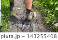 Hiker trekking close-up rear view along a muddy mountain trail in Svaneti, Georgia, showing wet terrain, hiking footwear performance, trail conditions, and outdoor route safety for trekking tourism 143255408