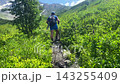 Male hiker walking in rear view along a narrow trail toward Shkhara Glacier near Ushguli, Svaneti, Georgia, promoting trekking tourism, mountain routes, outdoor adventure, and active travel marketing 143255409