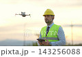 Exploring drone technology with an asian woman in a beautiful sunset setting 143256088