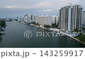 Aerial approach toward a cluster of miami beach high rises along a calm waterway 143259917
