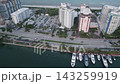 Aerial pass over a miami beach marina lined with yachts and waterfront towers 143259919