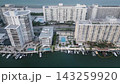 Aerial glide over a miami beach waterfront lined with towers and docked yachts 143259920