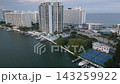 Aerial flyover of miami beach towers between a coastal waterway and the ocean 143259922