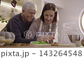 Family decorating Christmas gingerbread cookies with colorful icing cream 143264548