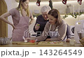 Family decorating Christmas gingerbread cookies with colorful icing cream 143264549