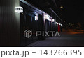 Illuminated storefront signs along a quiet street at night 143266395