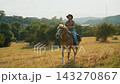 Cowboy man calmly rides horseback on a ride in the pristine nature Cowboy man calmly rides horseback on a ride in the pristine nature 143270867