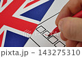 Voter ticks box next to their candidate on paper ballot with red marker 143275310