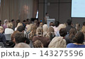 Attendee raising a smartphone during a conference presentation 143275596