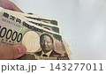 一隻手拿著一張攤開的鈔票 143277011