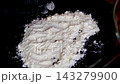 White flour on black plate prepared for coating fish meat and vegetables before frying or baking close up kitchen ingredient 143279900
