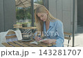 Peaceful Woman Reading Book And Drinking Coffee At Outdoor Street Cafe 143281707