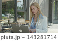 Businesswoman Reviewing Documents And Talking On Video Call At Outdoor Cafe 143281714