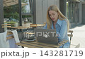 Freelancer Concentrating On Laptop Work While Sitting At Outdoor Coffee Terrace 143281719