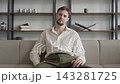 Relaxed Man Resting On Sofa Then Looking At Camera In Modern Home Interior 143281725