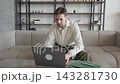 Focused Man Working On Laptop And Typing While Sitting On Sofa At Home 143281730