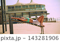 Asian woman strengthening core muscles on bench at seaside 143281906