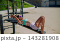 Person doing abdominal exercises on bench beside ocean view 143281908