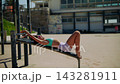Person engages in core workouts amid scenic waterfront and structures 143281911