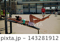 Caucasian athlete performing leg lifts at beach during sunny day 143281912