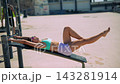Caucasian athlete strengthening muscles in sunny seaside setting 143281914