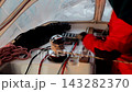 A man in the yacht cockpit loops a rope around the drum of an electric winch with a servo motor  143282370