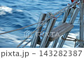 A shiny metal boarding ladder on the stern of a yacht sailing in the open sea 143282387